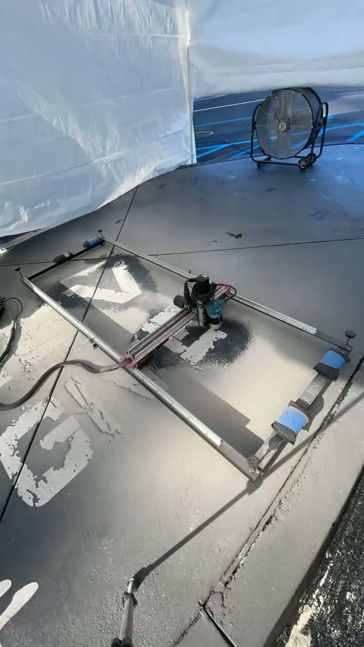 Portable CNC engraving machine cutting a design directly into a concrete surface