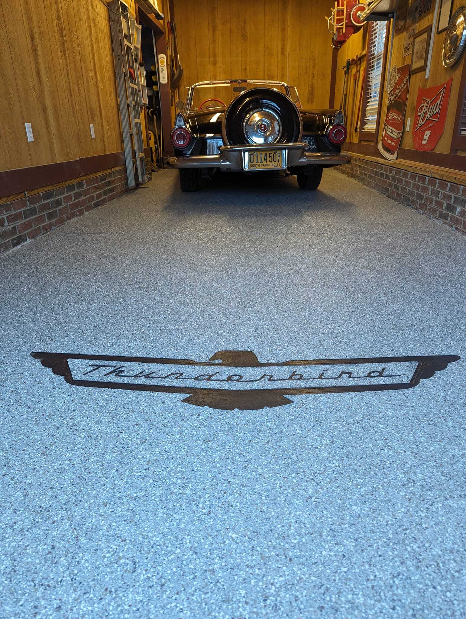 Classic car logo engraved directly into a garage floor coating, an example of custom concrete engraving
