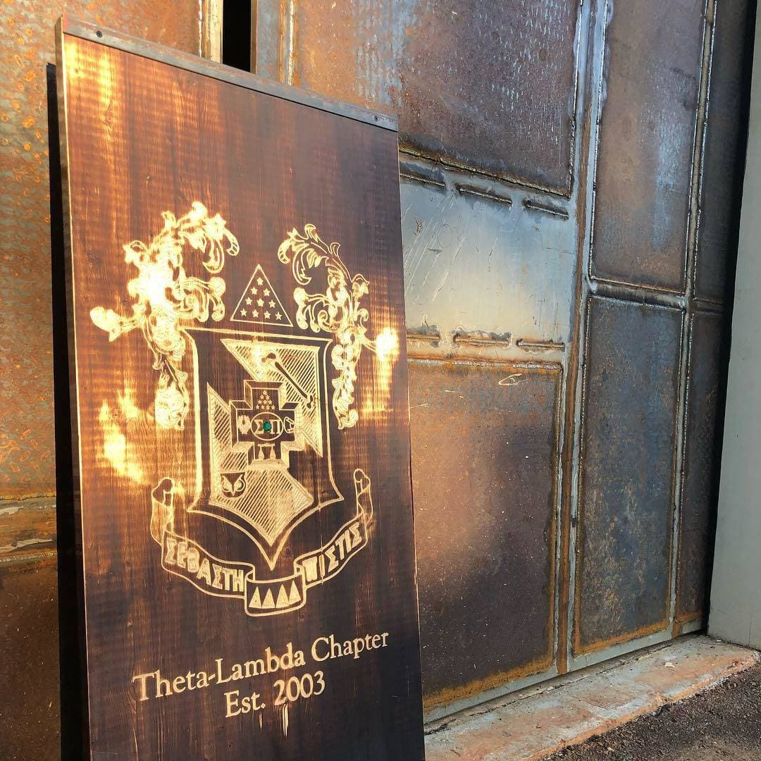 Crest logo engraved into a wood sign