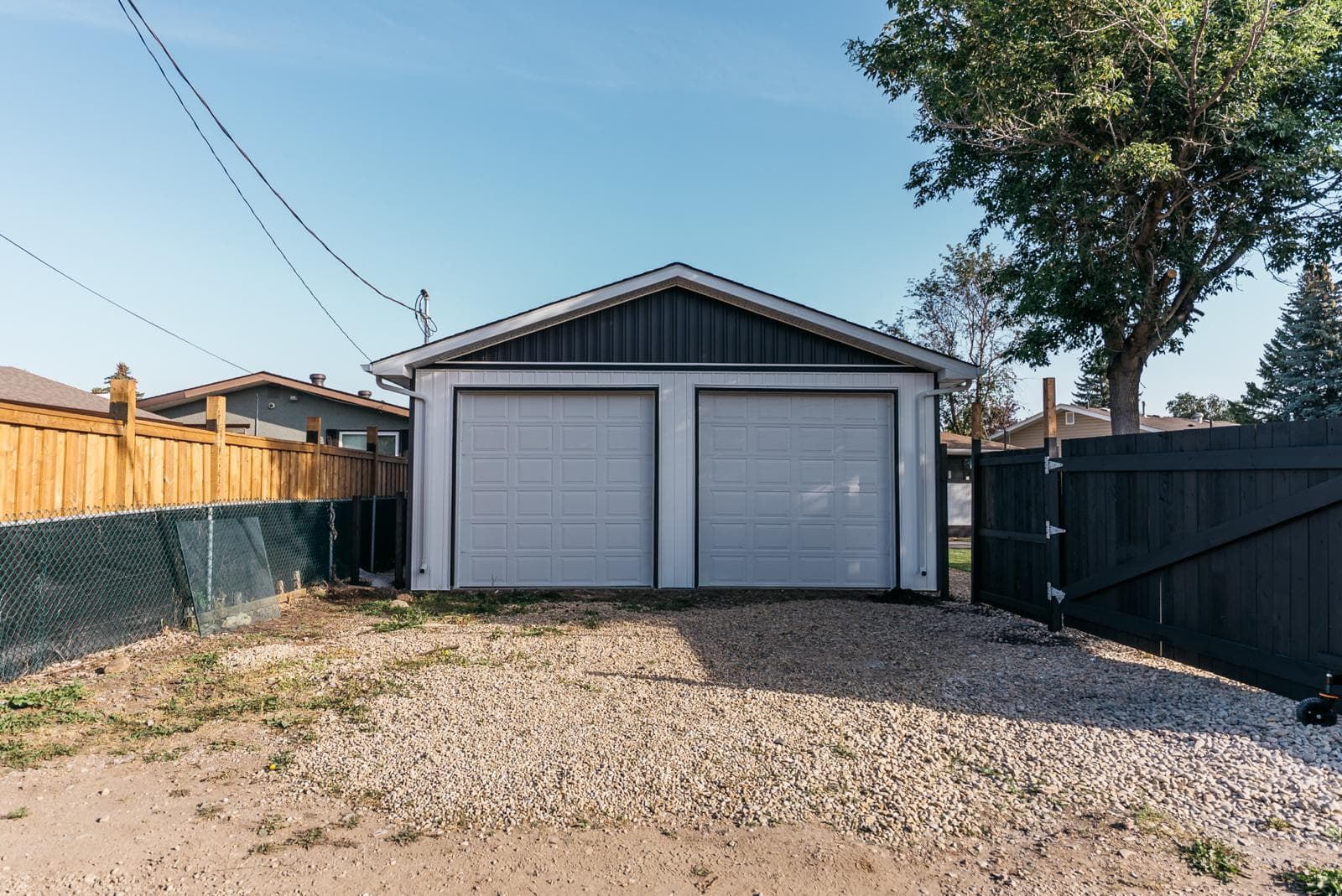 Detached double-bay garage with finished gray siding — JFK Surfaces Central Alberta build
