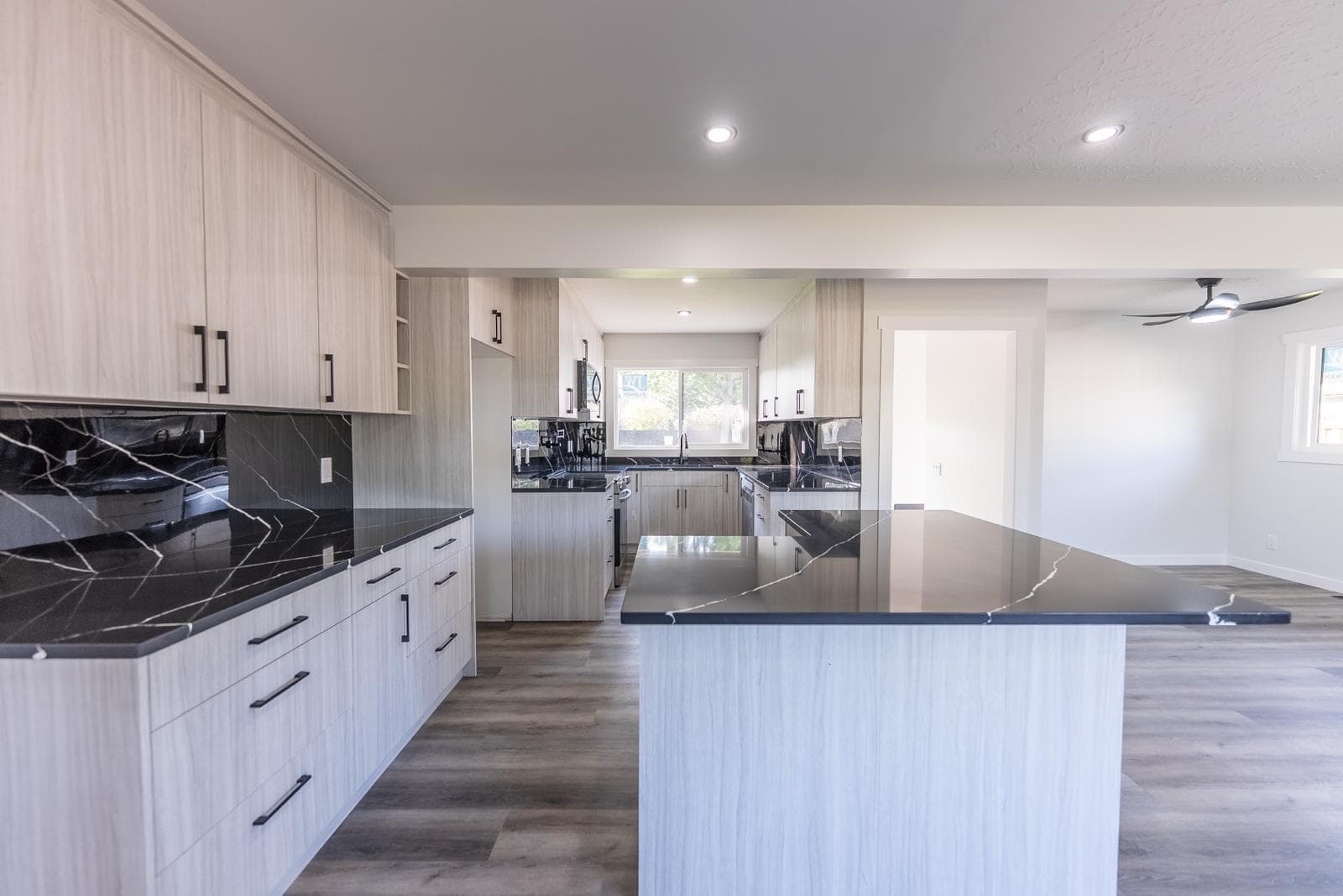 Open-concept kitchen with island and black quartz counters — JFK Surfaces renovation in Central Alberta