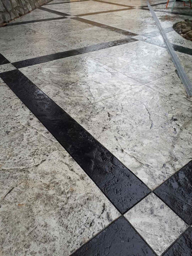 Checkerboard-pattern decorative concrete patio finished by JFK Surfaces in Sylvan Lake